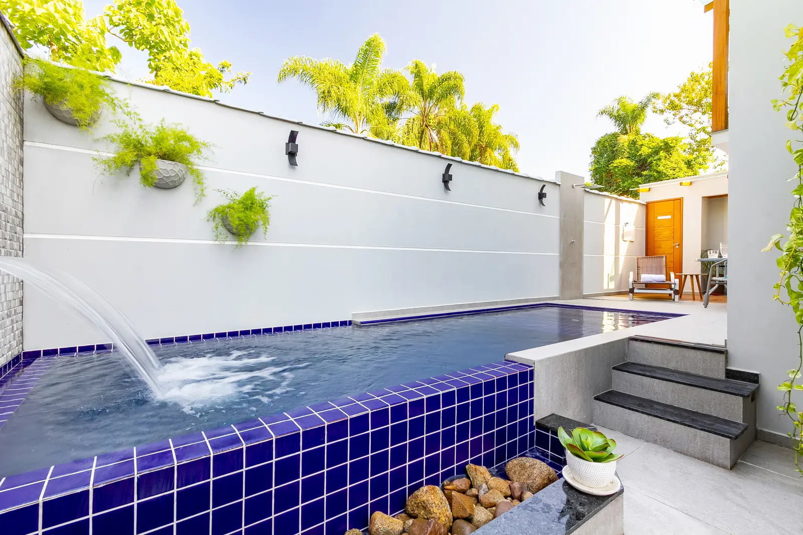 Piscina com cascata em dia de sol