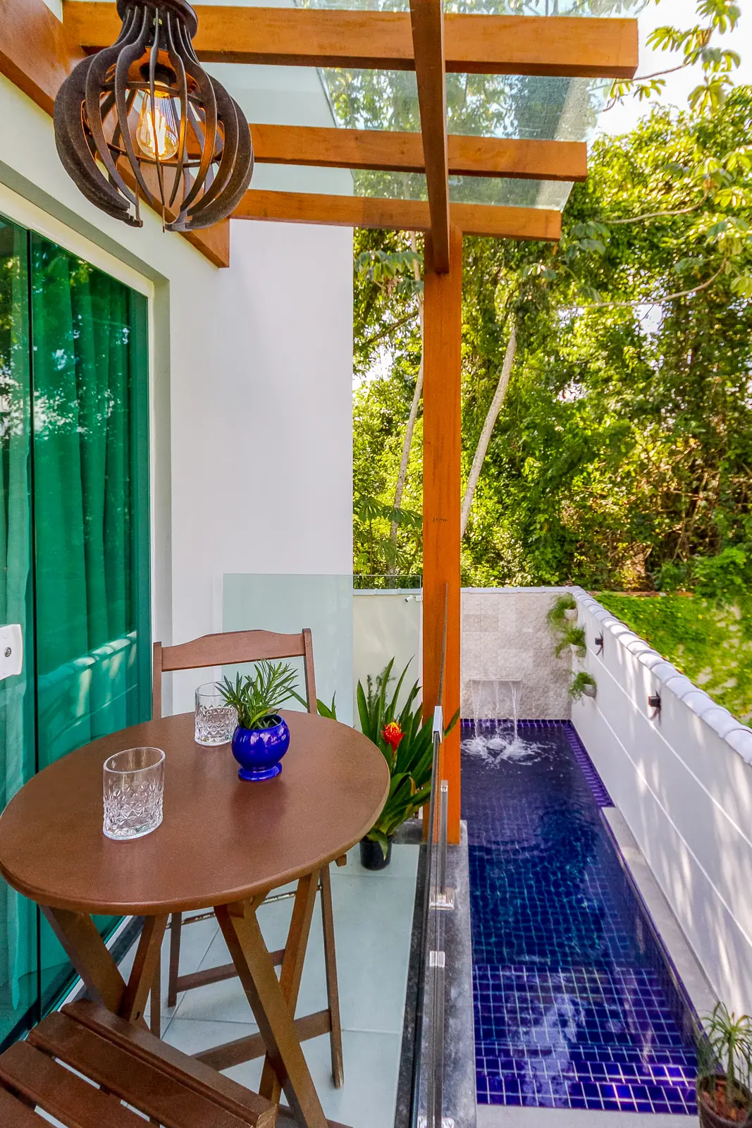 Varanda com mesa de apoio e a piscina logo abaixo