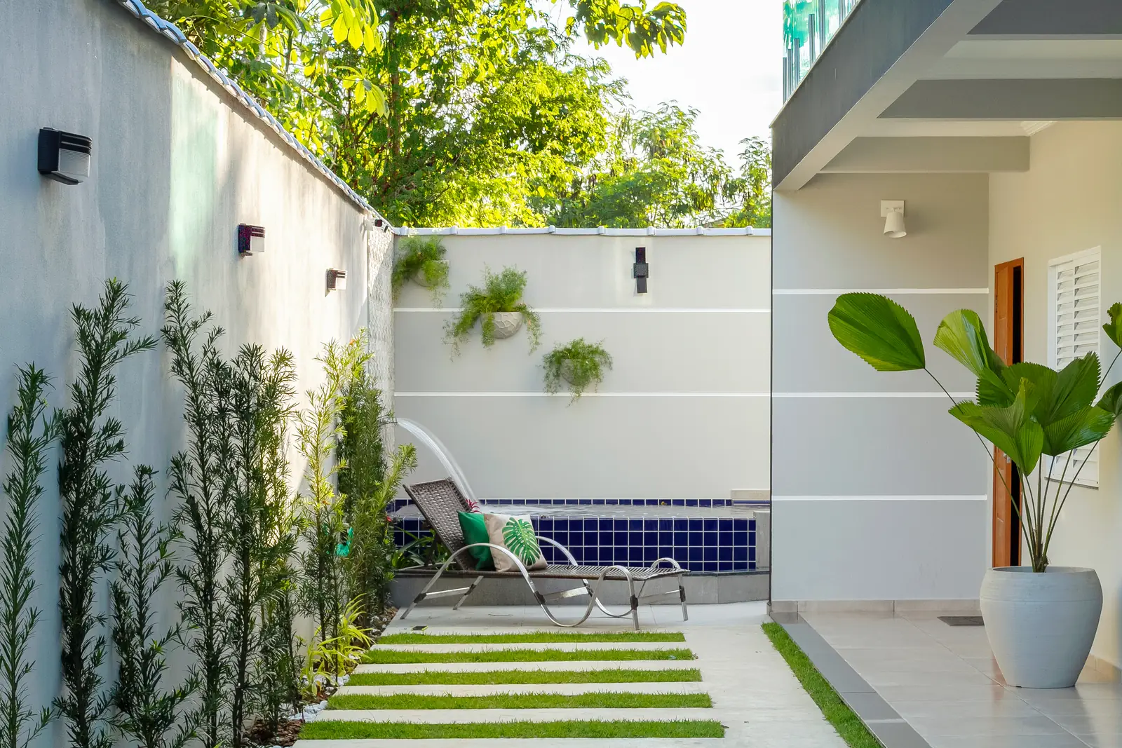 Área comum com jardim e piscina ao fundo