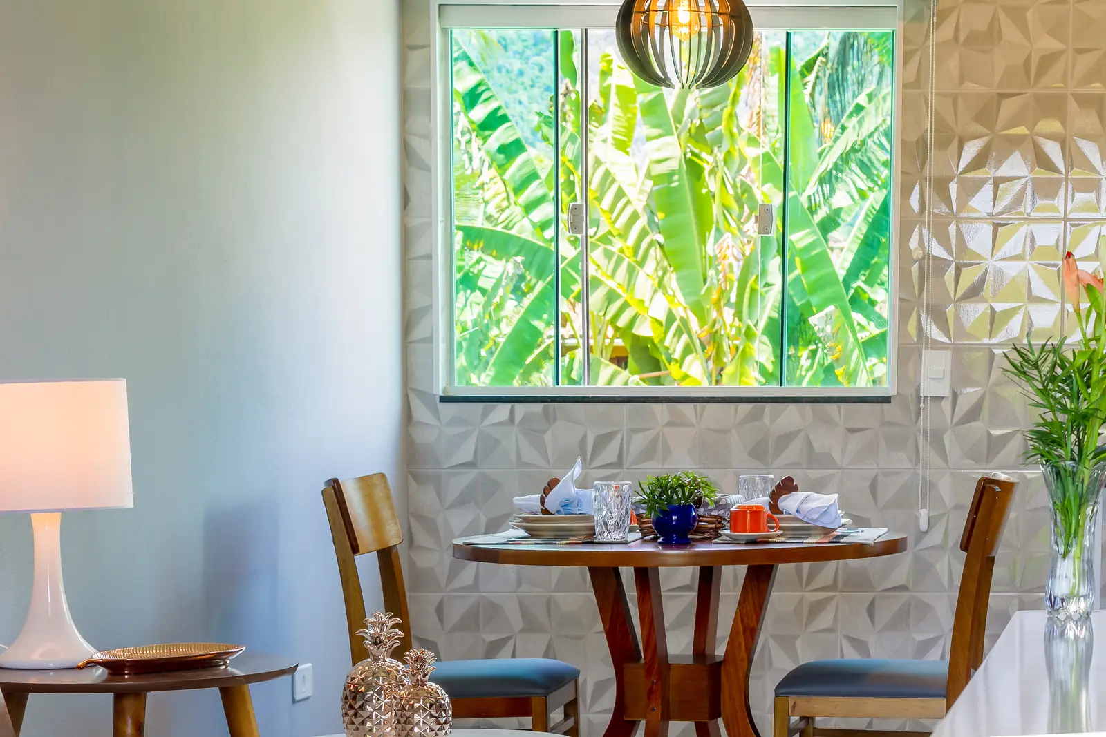 Mesa de refeições junto à janela com vista para o verde