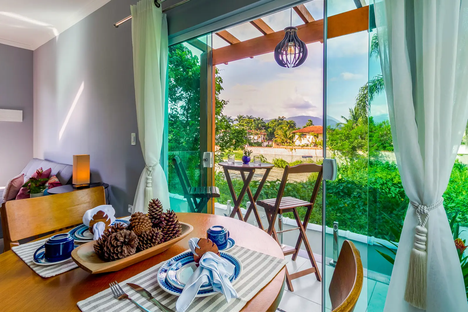 Apartamento Vista das Montanhas — sala aberta para a varanda e o verde